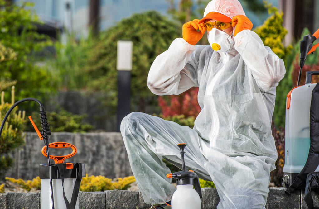 Licensed exterminator performing quarterly pest control barrier treatment in Alexandria VA
